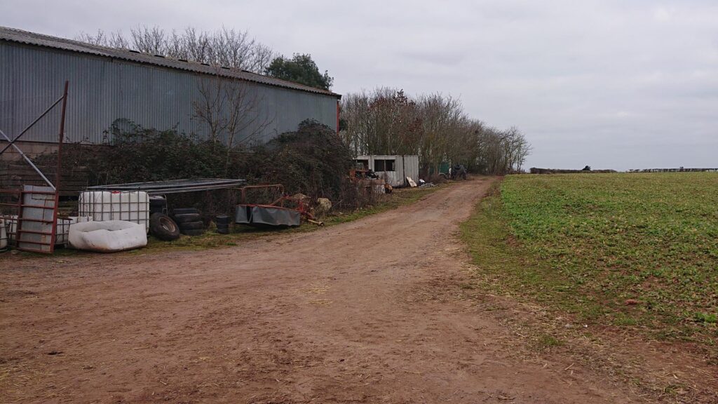 Farm buildings next to dirt track